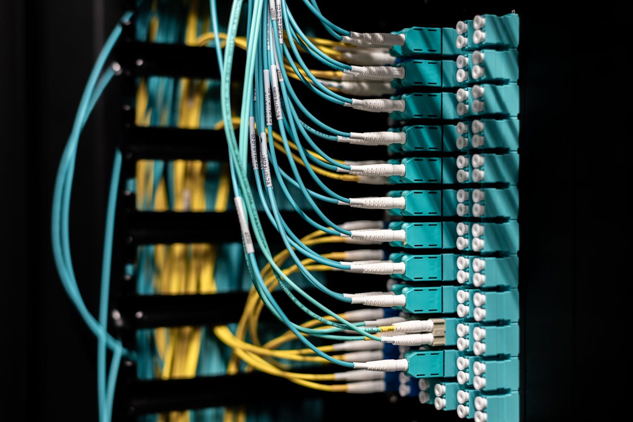 services-04 Closeup of electronic device with colorful wires installed in rows in communications room on blurred background in dark studio inside